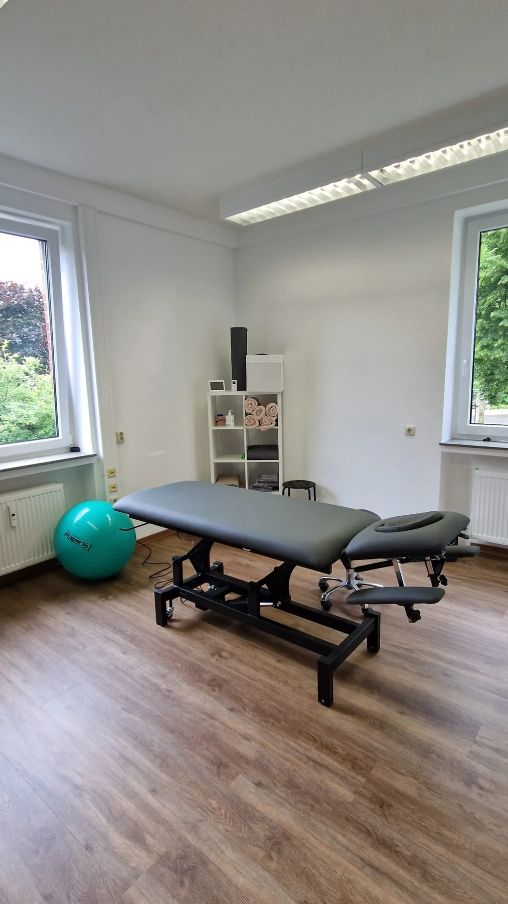 Heller Behandlungsraum mit Therapieliege und Gymnastikball
