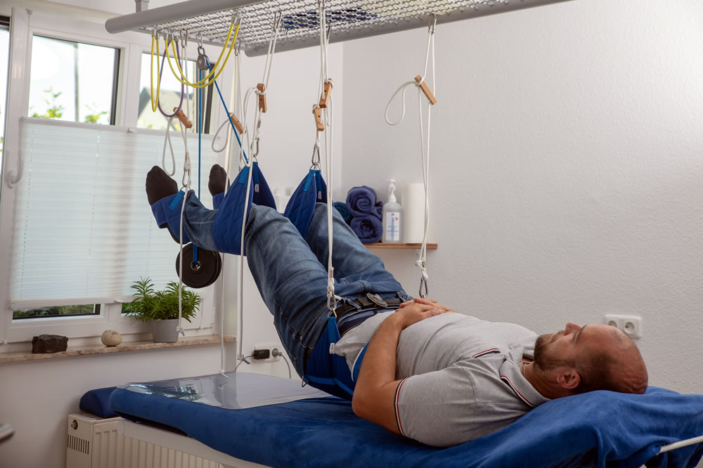 Bei dieser Therapieform wird der Körper oder einzelne Körperteile in speziellen Schlingen aufgehängt, um Bewegungen zu erleichtern und die Wirbelsäule sowie Gelenke zu entlasten. Dadurch können Schmerzen reduziert, Verspannungen gelöst und die Mobilität verbessert werden. Besonders geeignet bei Rücken- und Gelenkbeschwerden sowie neurologischen Erkrankungen.